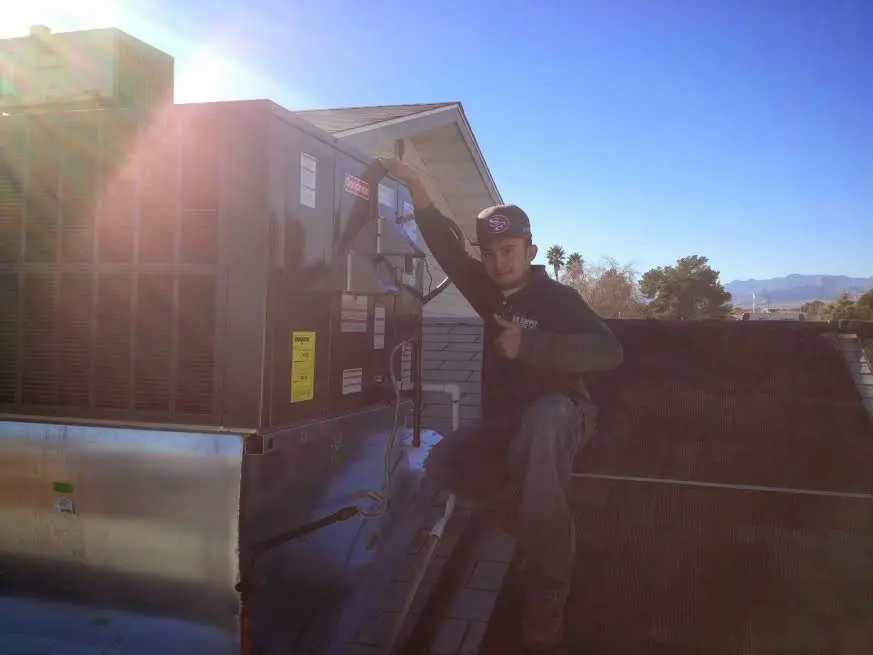 HVAC technician performing AC Tune-Up on a rooftop unit in Green Brook